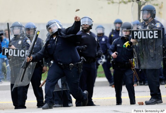 Police officer throwing debris, photographed by Patrick Semansky for the AP.